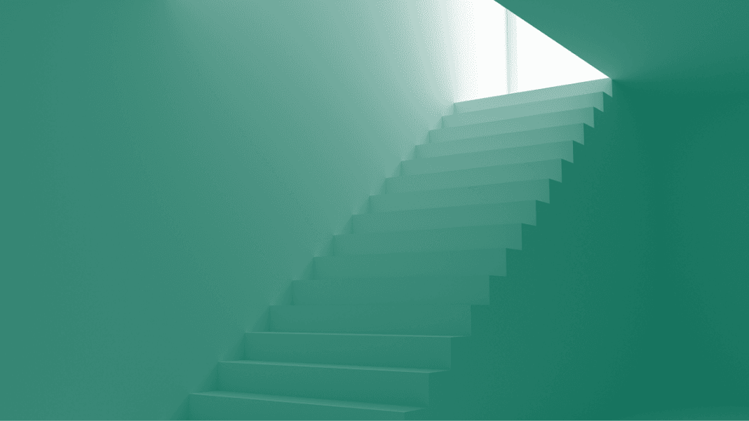 A minimalist teal staircase ascends towards a small, bright skylight. The geometric architecture and soft lighting create a tranquil, modern atmosphere.