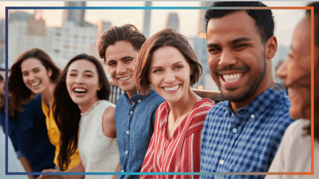 A diverse group of young adults smiling outdoors.