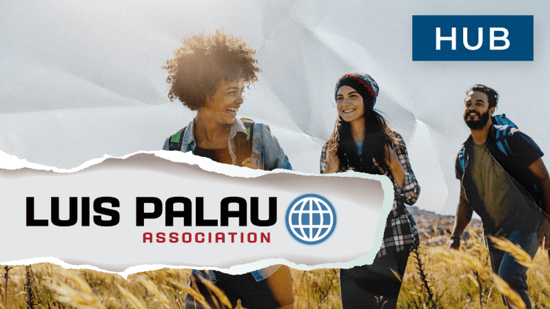 Three smiling young adults hike through a sunlit field of tall grass, with a torn paper overlay showing the Luis Palau Association logo and a blue ‘HUB’ label in the top right corner.