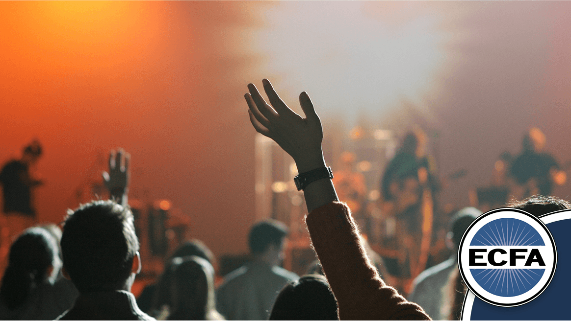 Person raising hand during a worship service, symbolizing church engagement. ECFA logo displayed.
